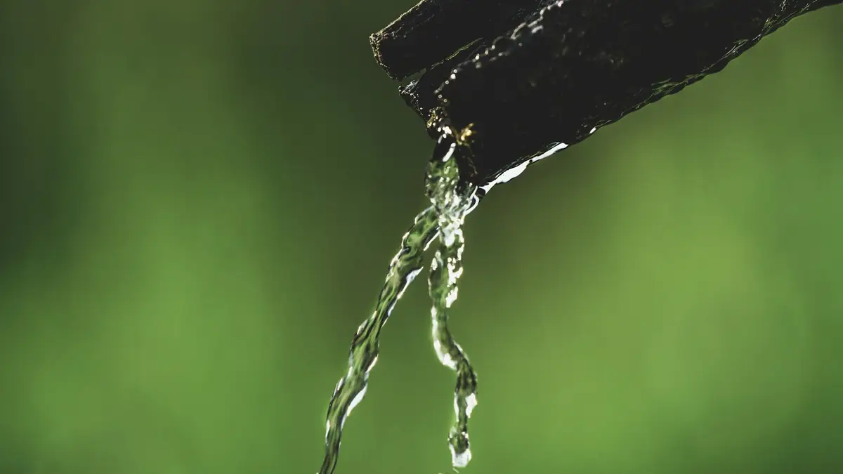Water dripping from the end of a dark pipe